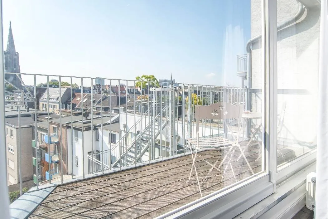 Balkon der Suite mit Sitzgruppe und Blick über die Dächer von Köln